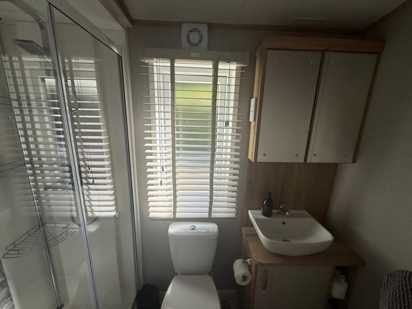 The shower room: walk-in shower cubicle, toilet and basin on an oak vanity