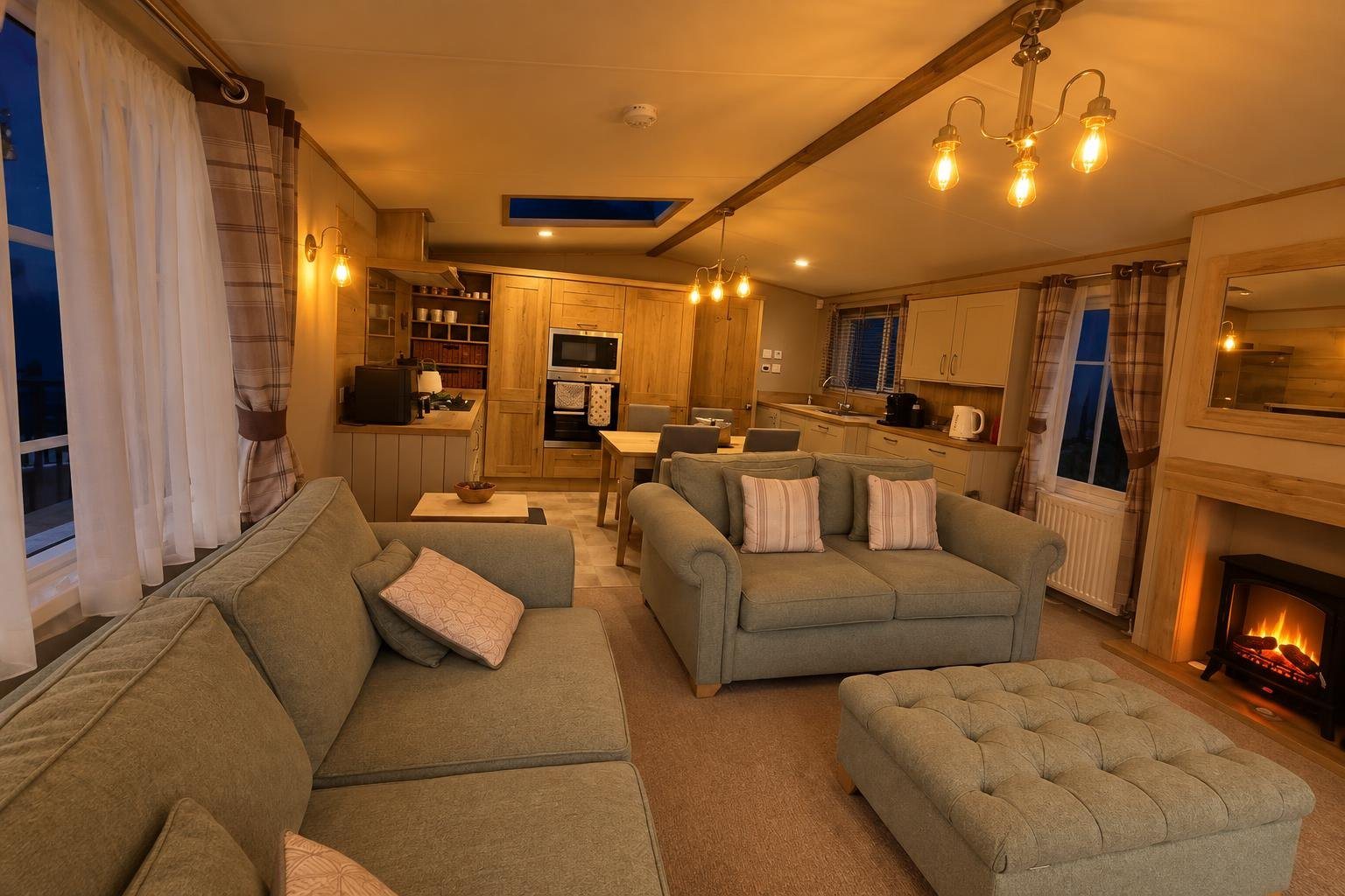 The open-plan lounge in the evening with the lamps, chandelier and fire on